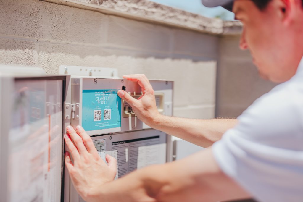 Team member putting Claffey Pools sticker up