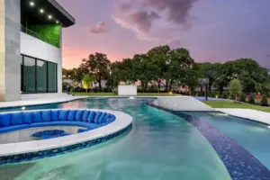 Pool side view of sunken fire pit and integrated seating in freeform pool
