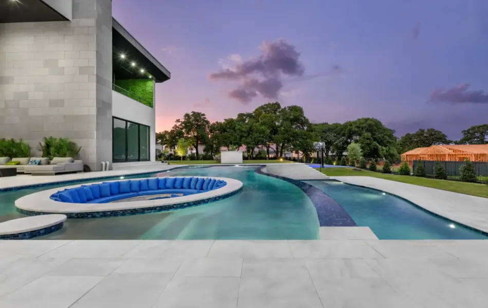 Pool side view of sunken fire pit and integrated seating in freeform pool