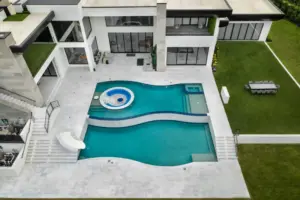 bird's eye-view of freeform pool with integrated sunken firepit and slide