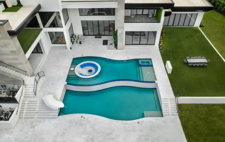 bird's eye-view of freeform pool with integrated sunken firepit and slide