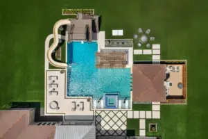 bird's eye-view of luxury pool with pool slide, integrated spa and tanning ledges