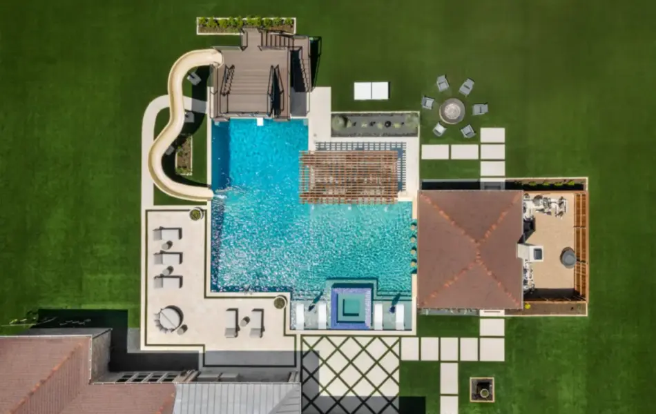 bird's eye-view of luxury pool with pool slide, integrated spa and tanning ledges