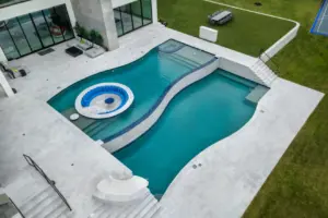 bird's eye-view of freeform pool with integrated sunken firepit and slide
