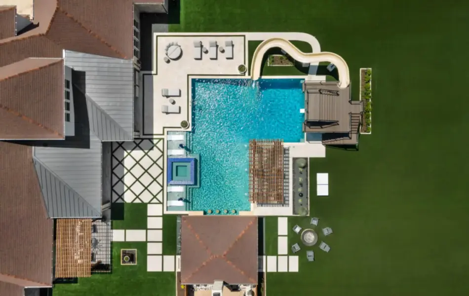bird's eye-view of luxury pool with pool slide, integrated spa and tanning ledges