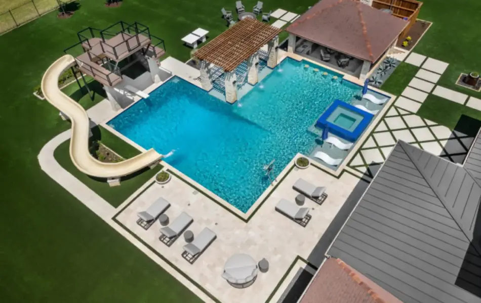 bird's eye-view of luxury pool with pool slide, integrated spa and tanning ledges