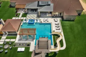 bird's eye-view of luxury pool with pool slide, integrated spa and tanning ledges