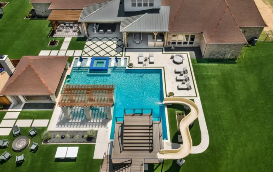 bird's eye-view of luxury pool with pool slide, integrated spa and tanning ledges