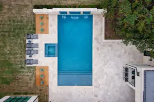 bird's eye-view of geometric pool with integrated spa and tanning ledges