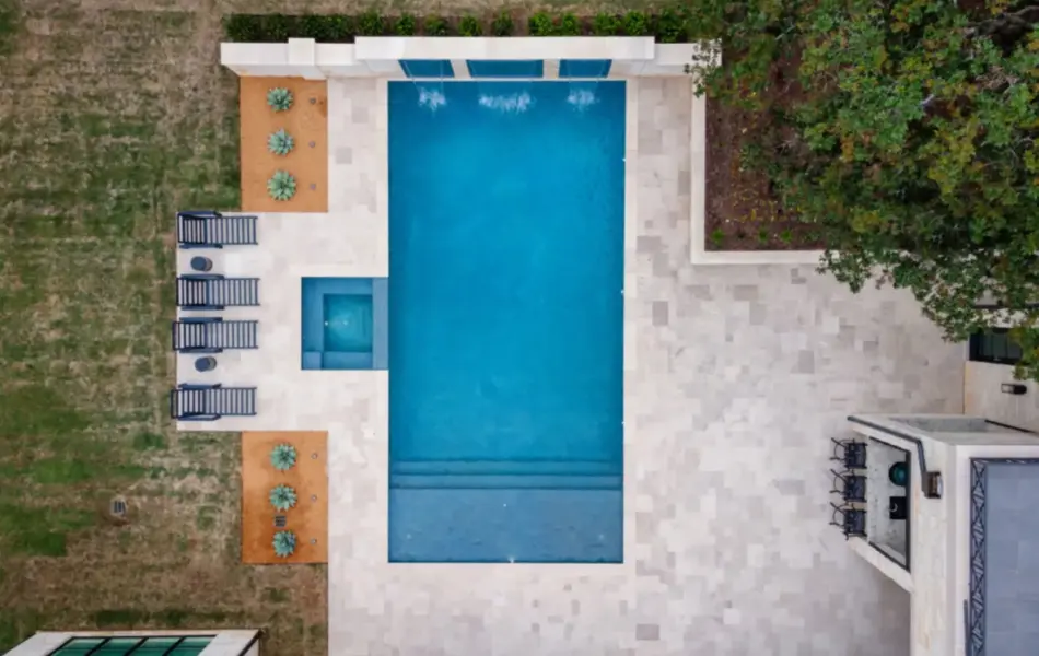 bird's eye-view of geometric pool with integrated spa and tanning ledges