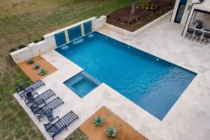 bird's eye-view of geometric pool with integrated spa and tanning ledges