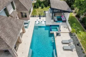 bird's eye-view of geometric pool with integrated spa, tanning ledges and cabana for outdoor living area