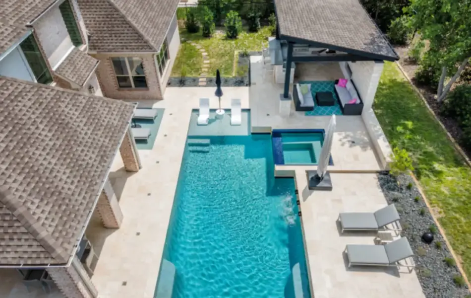 bird's eye-view of geometric pool with integrated spa, tanning ledges and cabana for outdoor living area