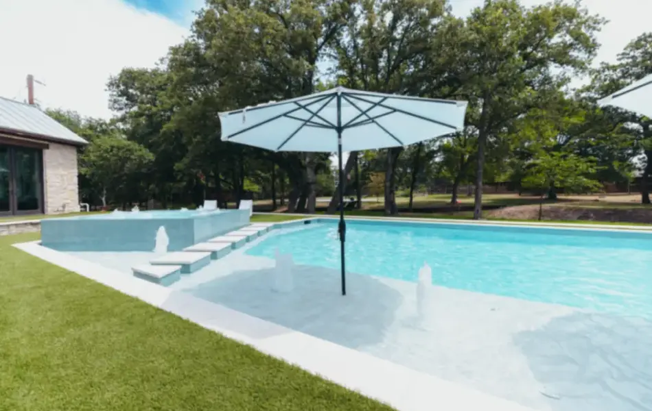 Parasol at edge of swimming pool with integrated water features